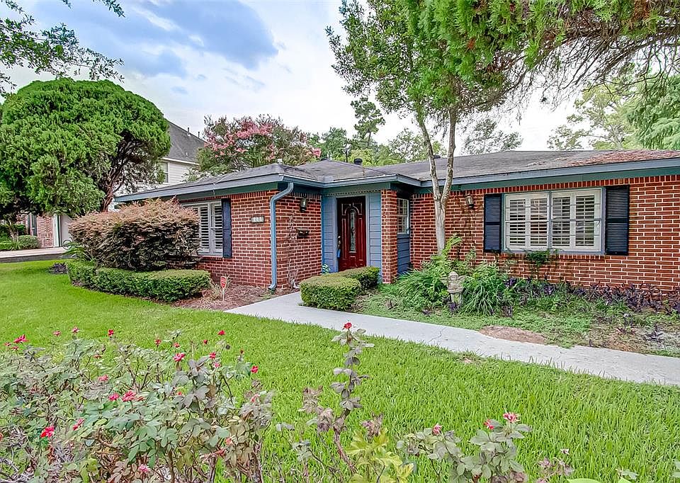 Brick ranch-style home with rose garden and mature shrubs
